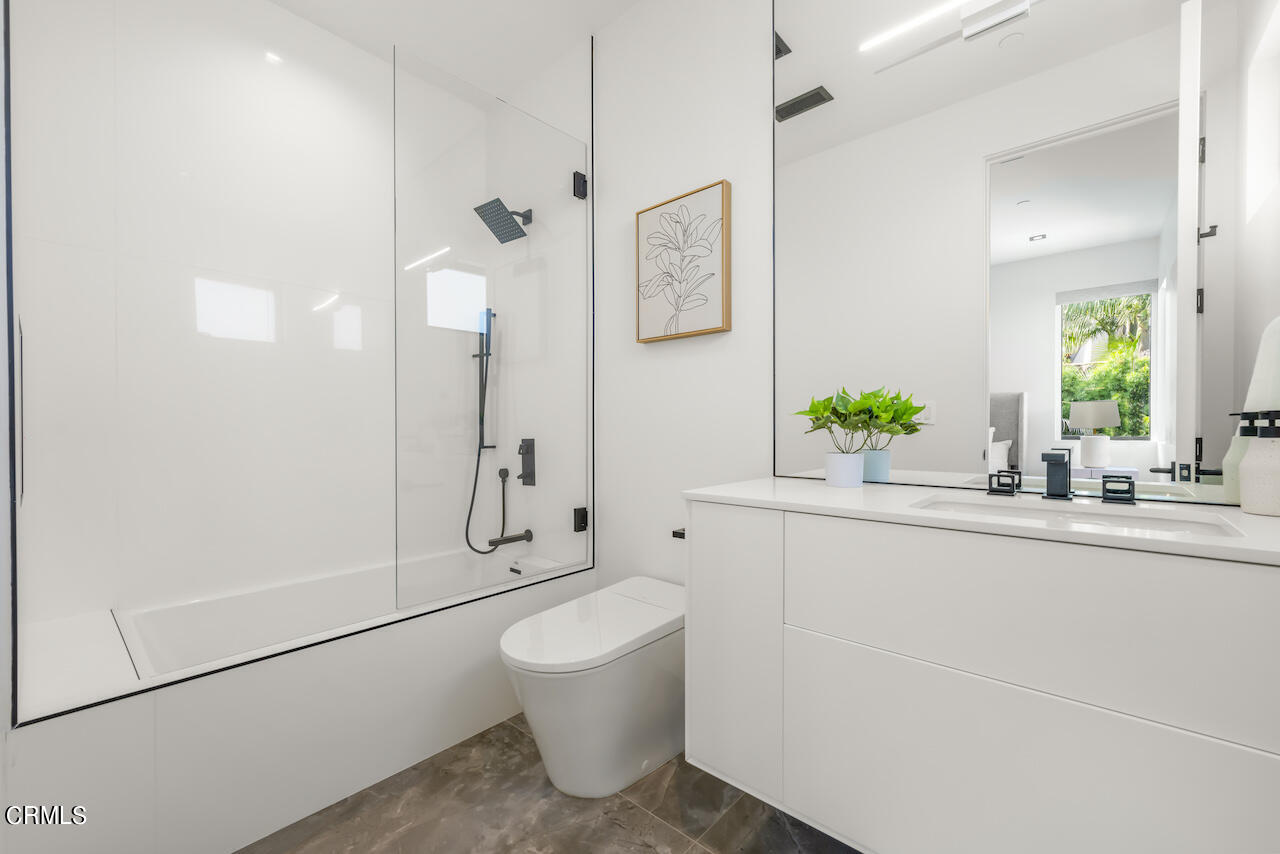 868 9th Street Manhattan Beach, CA 90266 - Photo 32 of 46 a bathroom with a granite countertop sink a toilet and mirror