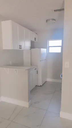 a view of a kitchen with white cabinets