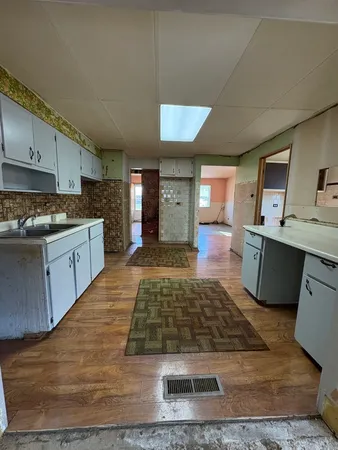a living room with stainless steel appliances granite countertop furniture wooden floor and a view of kitchen