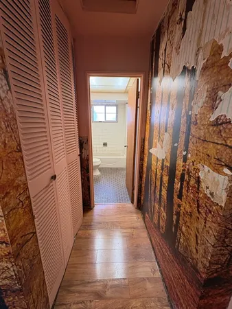 a view of a hallway with wooden floor and staircase