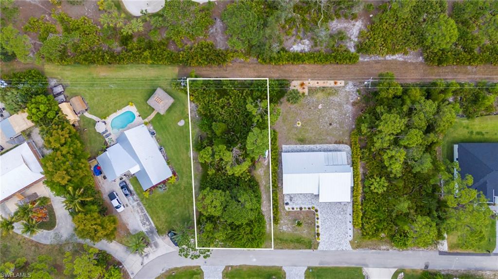 an aerial view of a house with outdoor space lake and trees all around