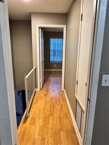 a view of a hallway with wooden floor and staircase