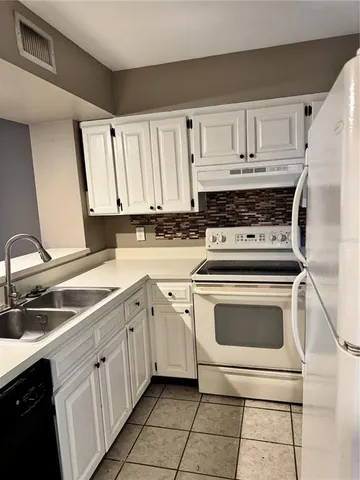 a kitchen with cabinets appliances a sink and a stove