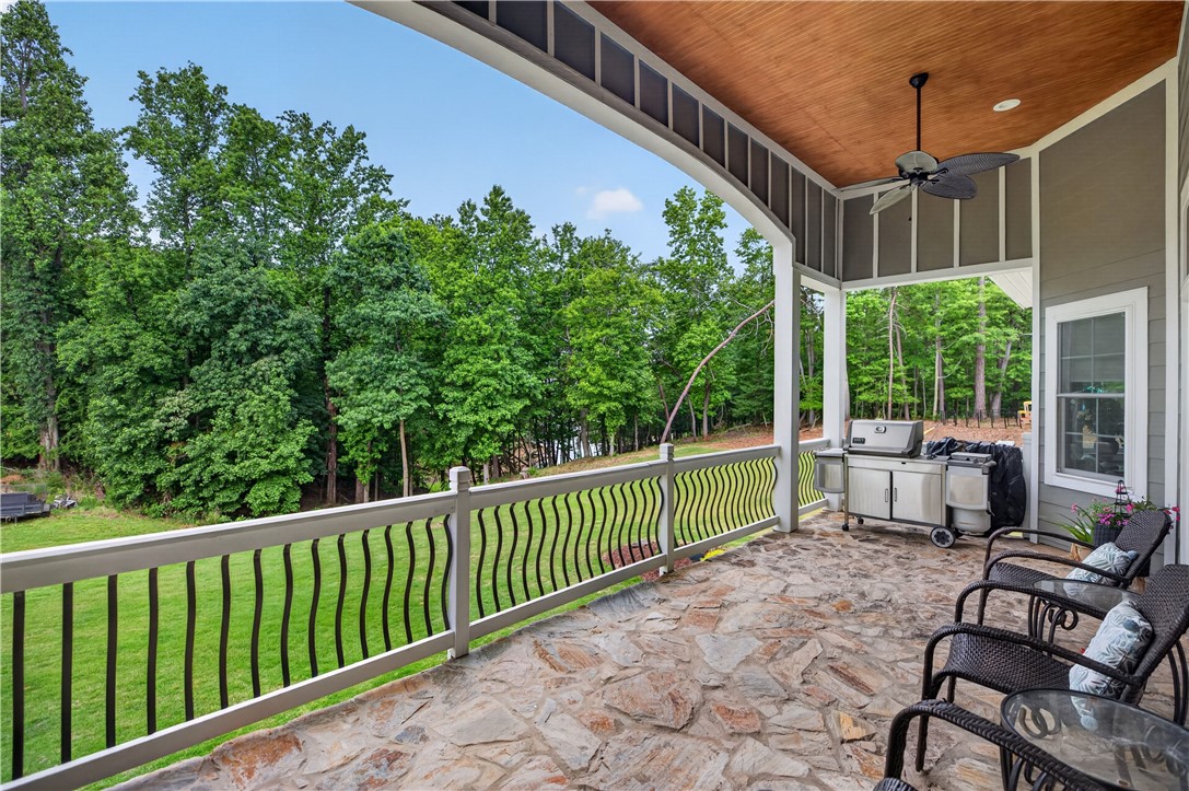 206 James Hare Road Anderson, SC 29626 - Photo 24 of 37 A spacious covered patio with natural stone flooring offers serene views of lush, mature trees.