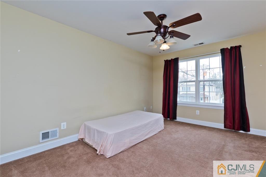 710 Spruce Road North Brunswick, NJ 08902 - Photo 22 of 28 a bed room with a bed and a ceiling fan