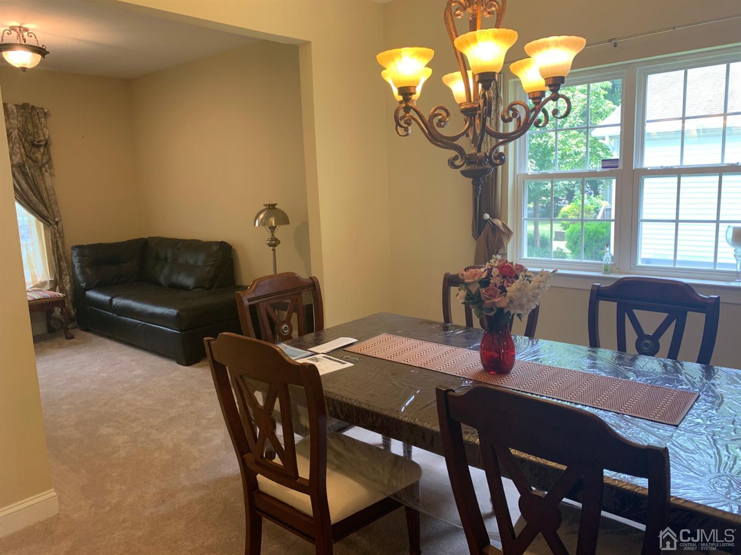 710 Spruce Road North Brunswick, NJ 08902 - Photo 8 of 28 a view of a dining room with furniture a chandelier and large windows