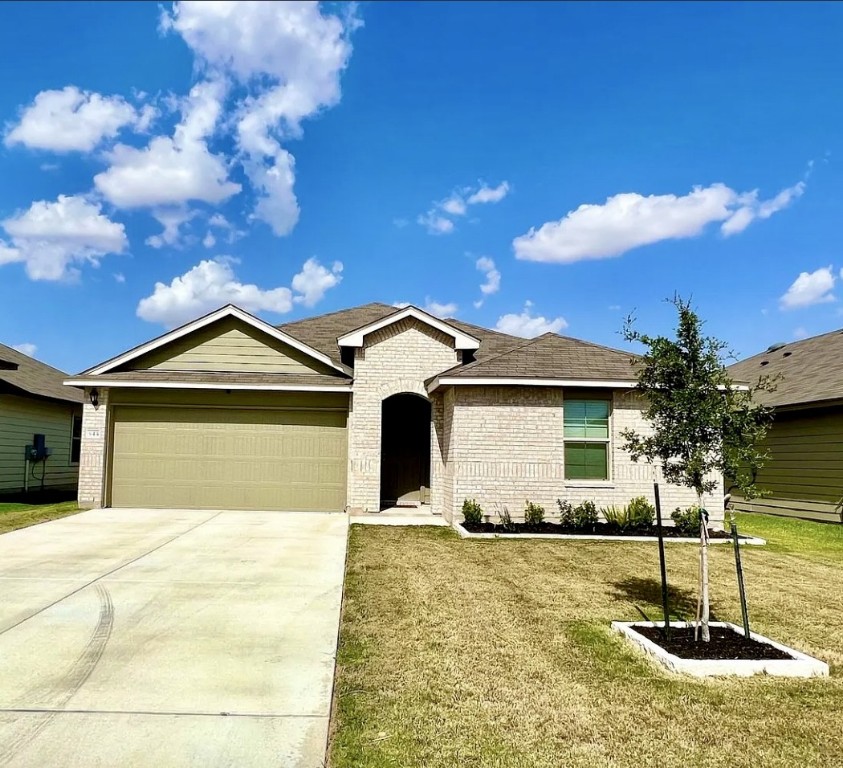 Ranch-style house with brick siding, concrete driveway, a front lawn, and a garage