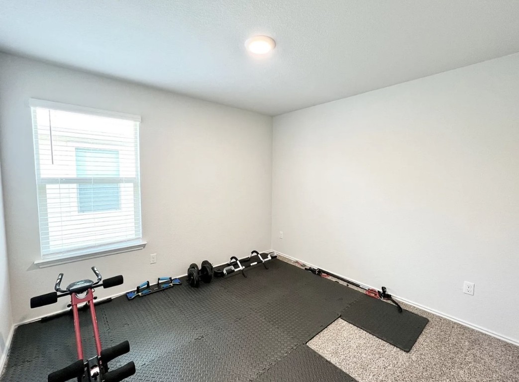 544 Taggart Trail Jarrell, TX 76537 - Photo 12 of 19 an empty room with a wooden floor and a window