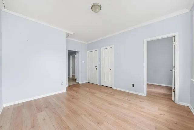 a view of an empty room with wooden floor