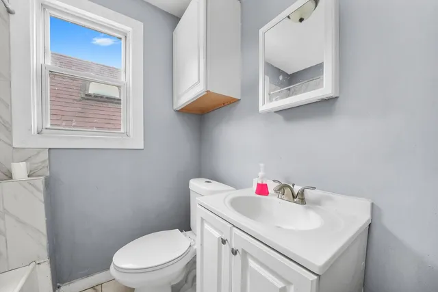 a white toilet sitting next to a bathroom sink