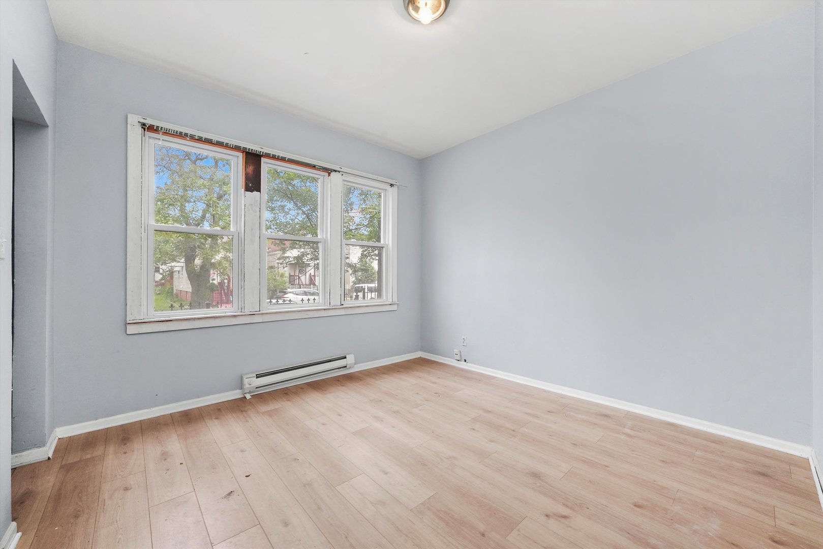 5014 South Paulina Street Chicago, IL 60609 - Photo 8 of 38 an empty room with wooden floor and windows