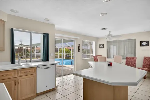 a large white kitchen with a sink and large window