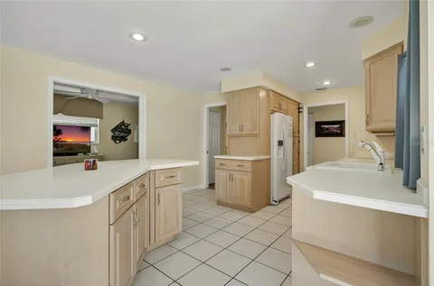 a large white kitchen with a sink a refrigerator and a stove