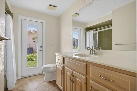 a bathroom with a granite countertop sink a toilet a mirror and shower
