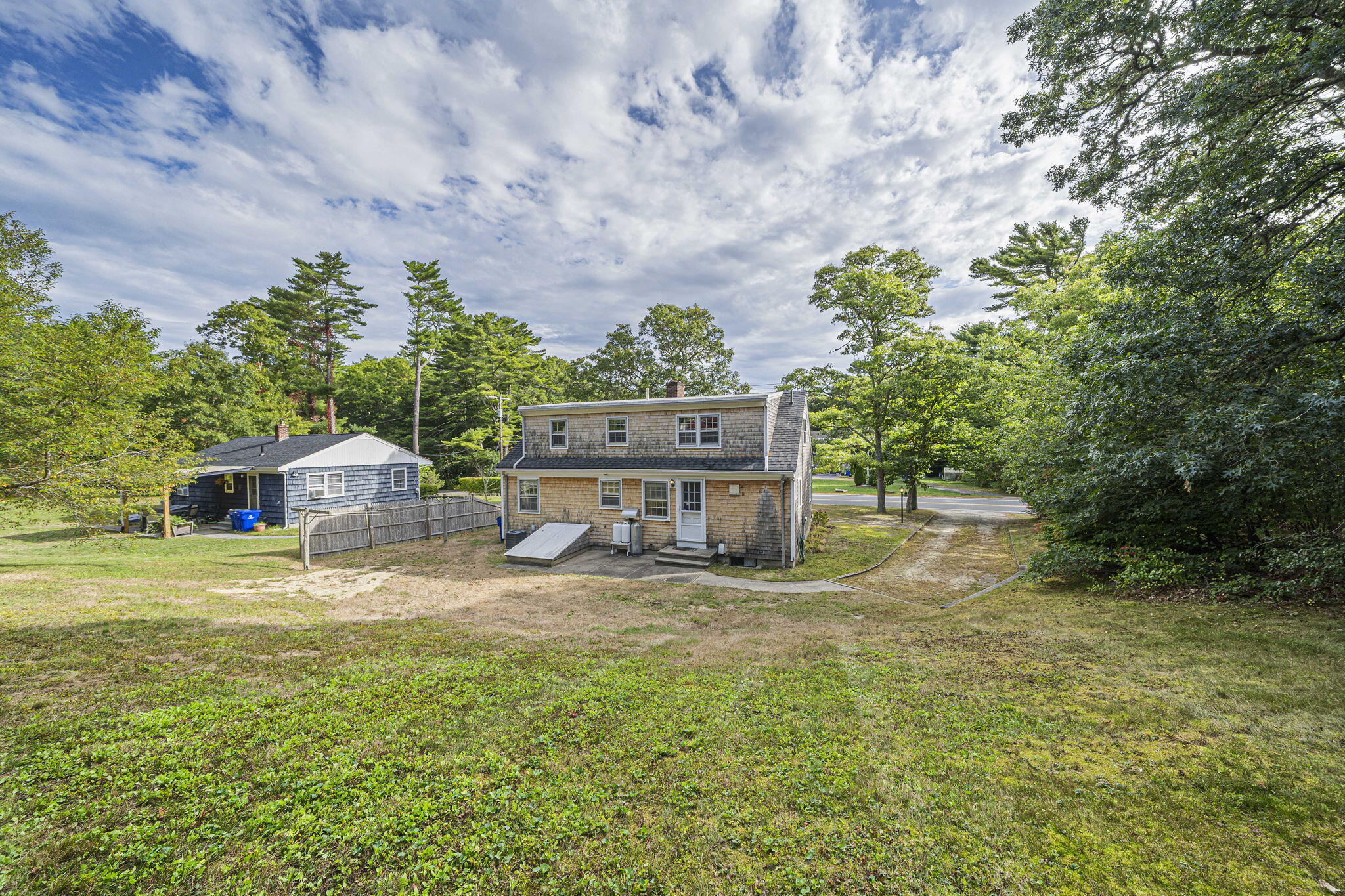 606 County Road Pocasset, MA 02559 - Photo 2 of 36 a view of a big house with a big yard and large trees