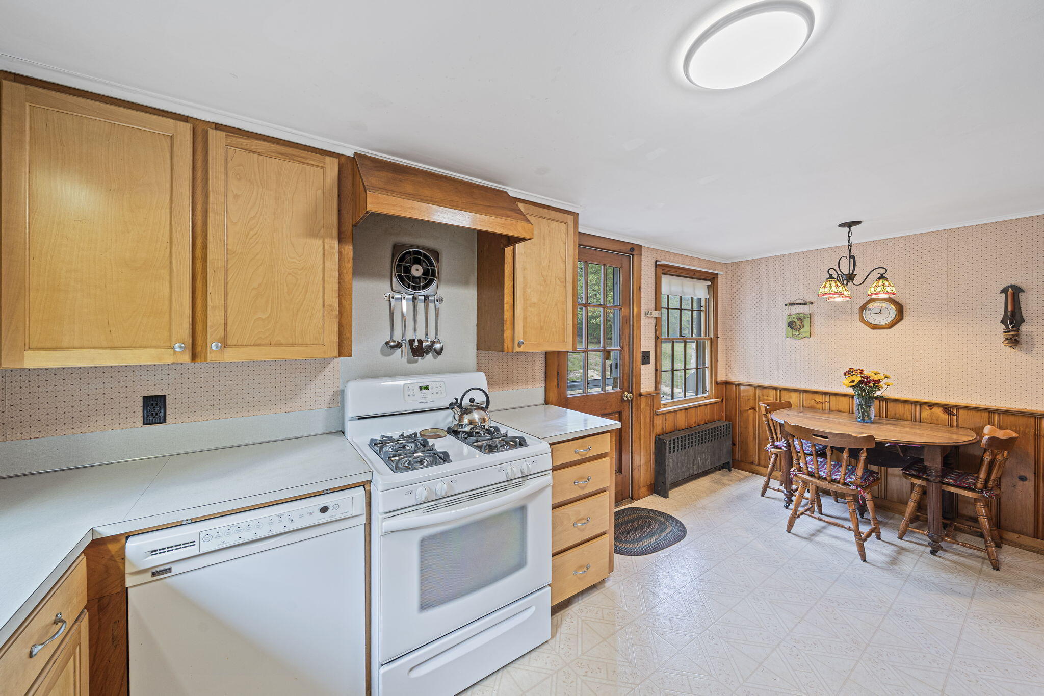 606 County Road Pocasset, MA 02559 - Photo 4 of 36 a kitchen with a stove a sink cabinets and a dining table