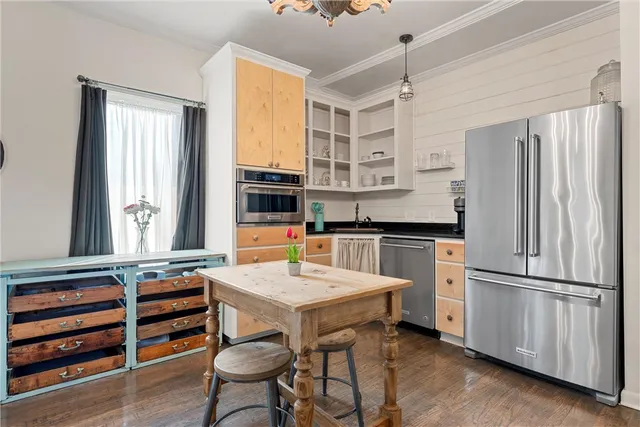 a kitchen with stainless steel appliances a stove a refrigerator and wooden cabinets