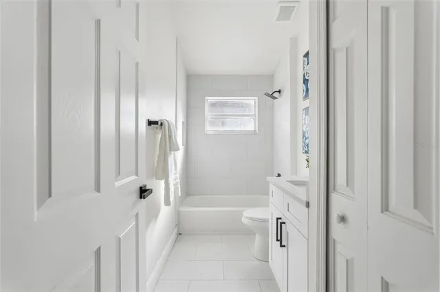 a bathroom with a tub shower and a sink