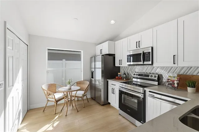 a kitchen with stainless steel appliances a stove a sink refrigerator and a microwave