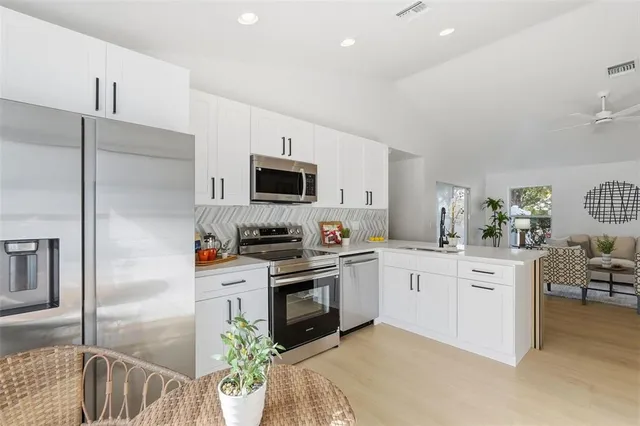 a kitchen with stainless steel appliances a white cabinets stove and refrigerator
