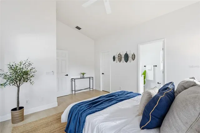 a bedroom with a bed and a potted plant