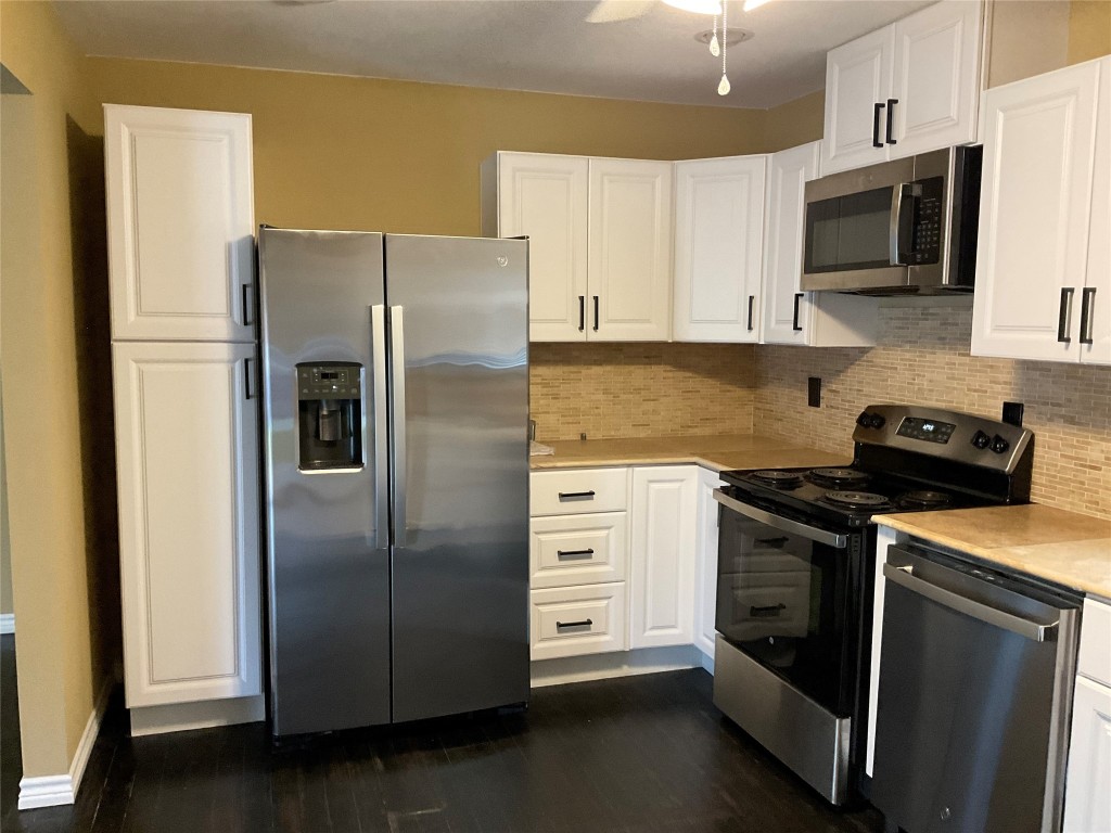 207 South George Street Victoria, TX 77901 - Photo 18 of 27 a kitchen with stainless steel appliances granite countertop a refrigerator stove a sink and a microwave