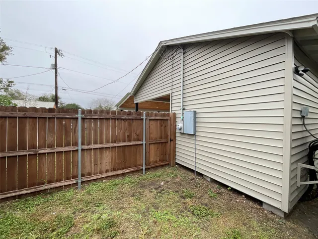 a view of a house with a yard and wooden fence