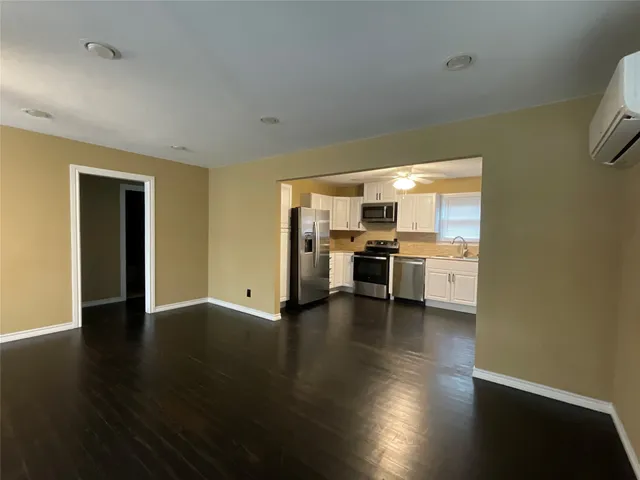 a view of a kitchen with kitchen island a sink wooden floor and a counter top space