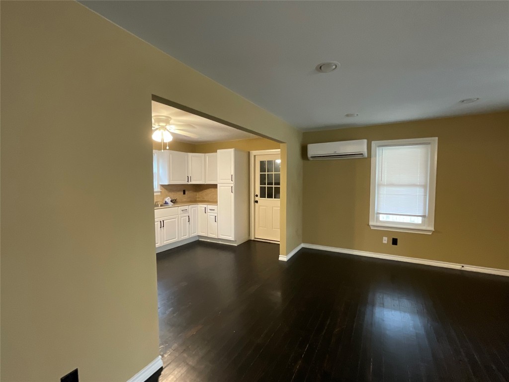 207 South George Street Victoria, TX 77901 - Photo 5 of 27 a view of an empty room with a window and wooden floor