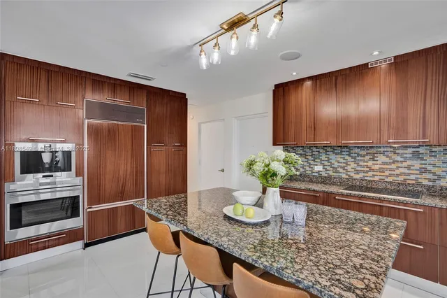 a kitchen with sink a microwave and cabinets