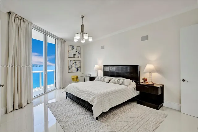 a bedroom with a large bed and a chandelier