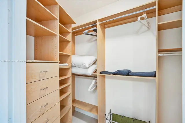 a view of walk in closet with empty racks