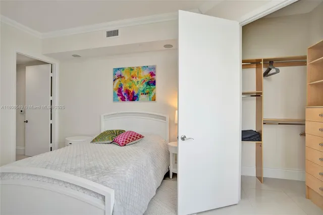 a bedroom with a bed and a refrigerator