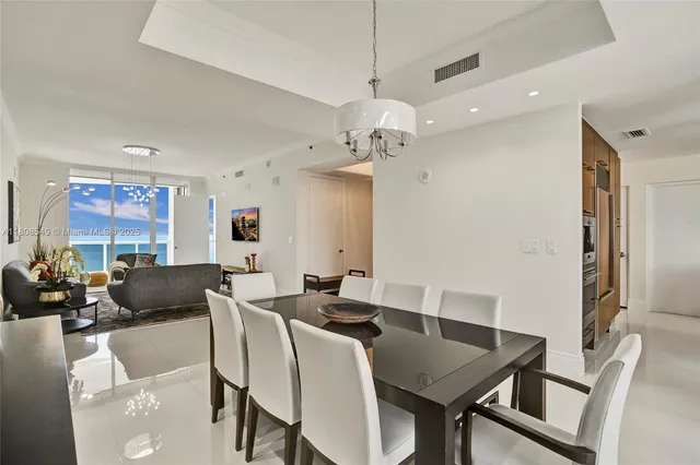 a view of a dining room with furniture and a chandelier