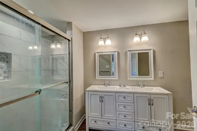a bathroom with double vanity sink and a mirror