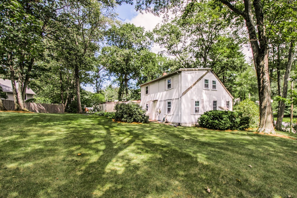 59 Munroe Road Lexington, MA 02421 - Photo 26 of 29 a view of a white house in front of a big yard with large trees