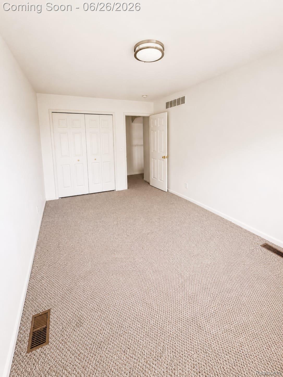 17014 Country Ridge Lane Macomb, MI 48044 - Photo 16 of 25 Carpeted room featuring white walls, a flush-mount ceiling light fixture, and white bi-fold closet doors