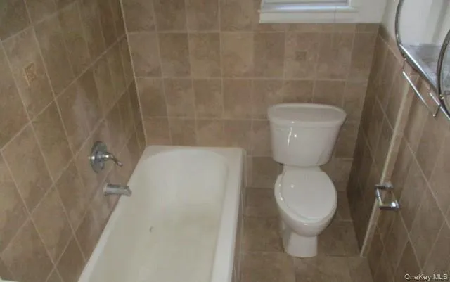 a white toilet sitting next to a white wall