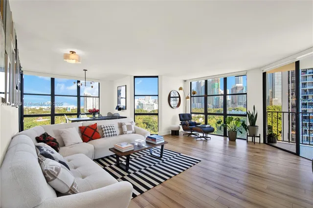 a living room with furniture floor to ceiling window and wooden floor