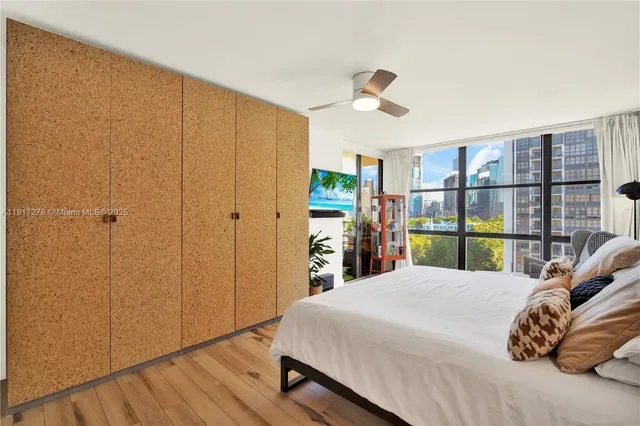 a bedroom with a bed and a large window