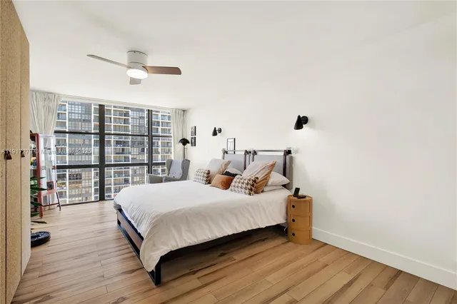 a bedroom with a large bed and a potted plant