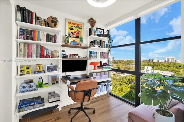 a living room with furniture a flat screen tv and a floor to ceiling window