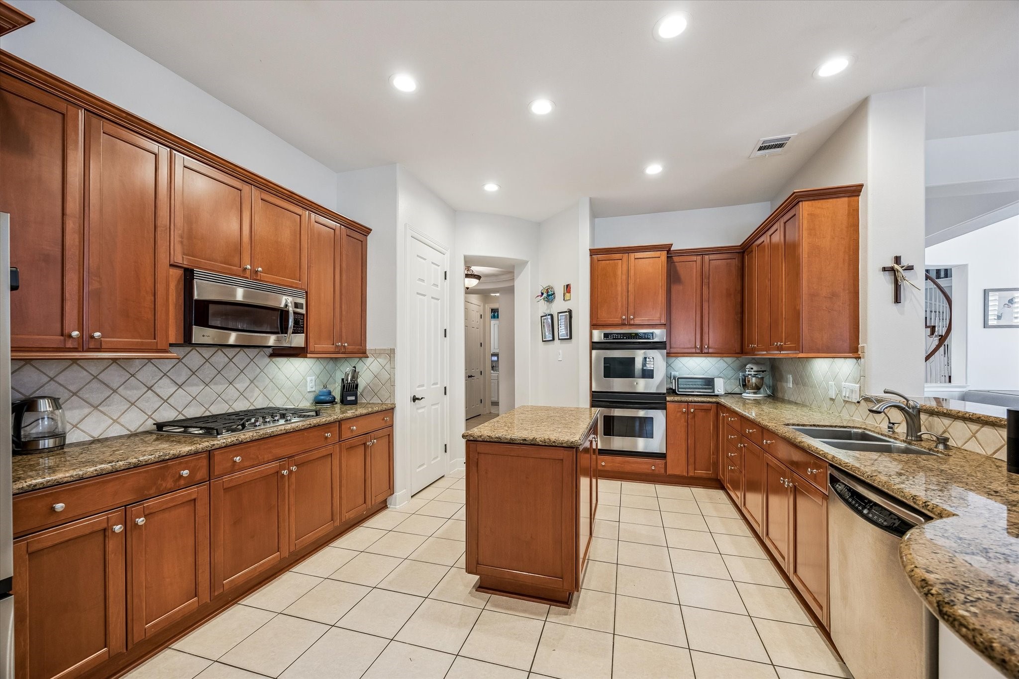 3047 Bonnebridge Way Boulevard Houston, TX 77082 - Photo 35 of 50 The kitchen features stainless steel appliances, a gas cooktop, neutral backsplash, under-cabinet lighting, abundant cabinetry, and a spacious walk-in pantry.