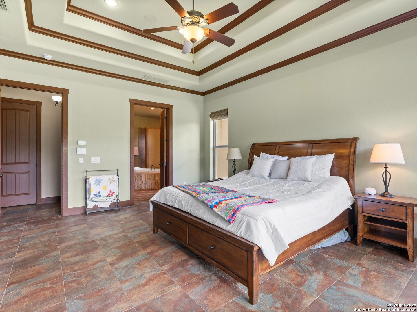 103 Falcon Crest Boerne, TX 78006 - Photo 16 of 35 a spacious bedroom with a bed and a chandelier