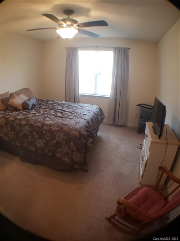 8360 Rudolph Road, Unit 2105 Charlotte, NC 28216 - Photo 13 of 14 a bedroom with a bed and a chair