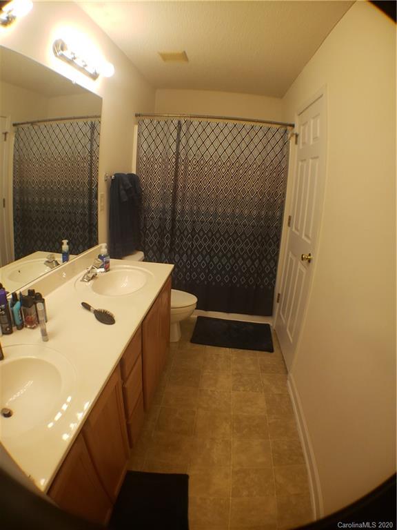 8360 Rudolph Road, Unit 2105 Charlotte, NC 28216 - Photo 6 of 14 a bathroom with a sink and a mirror