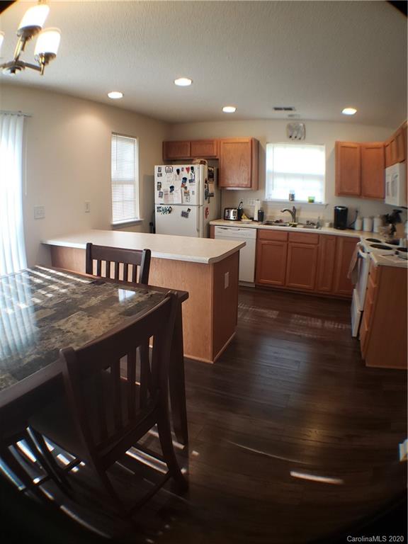 8360 Rudolph Road, Unit 2105 Charlotte, NC 28216 - Photo 9 of 14 a kitchen with granite countertop a stove a sink and a refrigerator