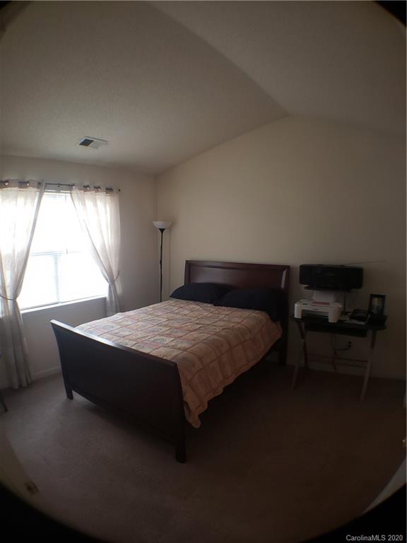 8360 Rudolph Road, Unit 2105 Charlotte, NC 28216 - Photo 10 of 14 a bed sitting in a bedroom next to a window