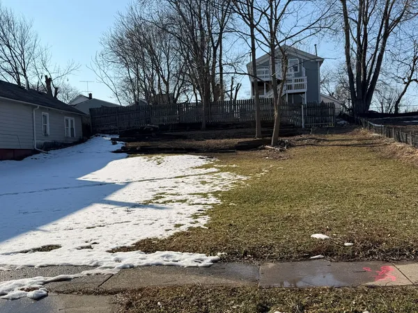 a view of yard covered with snow in front of house