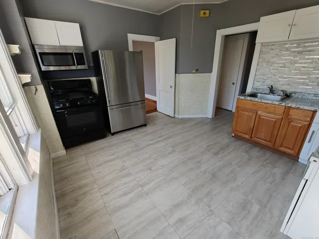 a kitchen with granite countertop a refrigerator and a stove